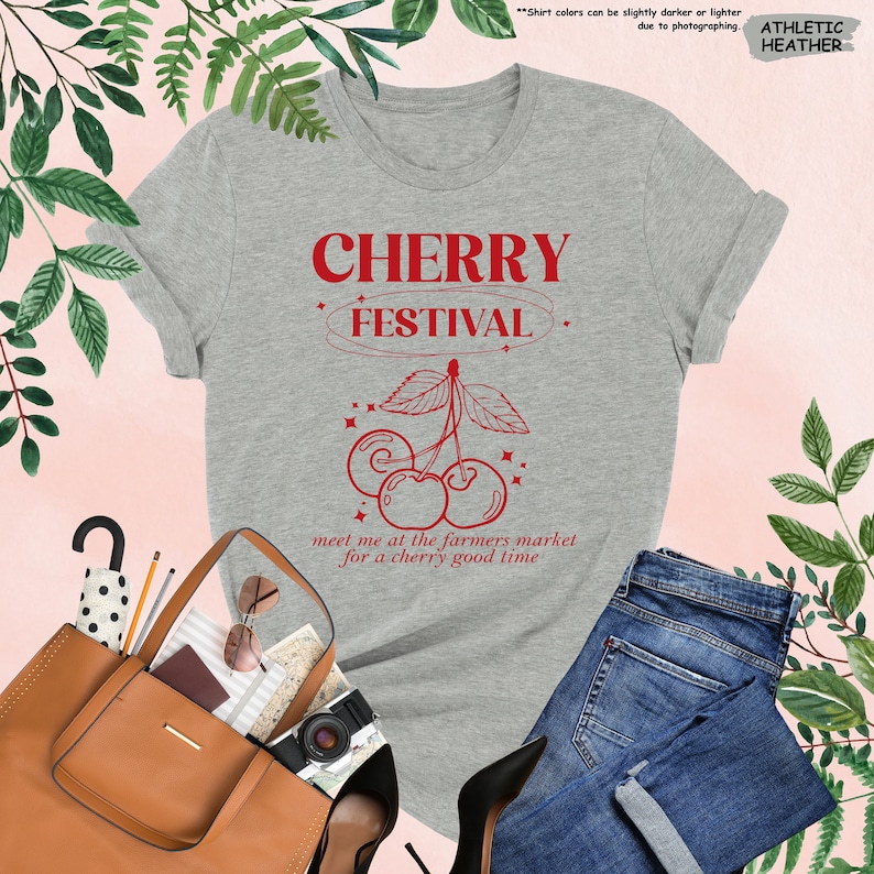 a t - shirt that says cherry festival next to a purse