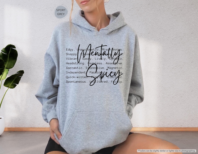 May include: Sport grey hoodie with the words "Mentally Spicy" in a black script font. The hoodie has a drawstring hood and a front pocket. The text is surrounded by a list of adjectives.