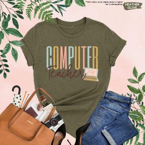 a women's t - shirt that says computer teacher next to a handbag