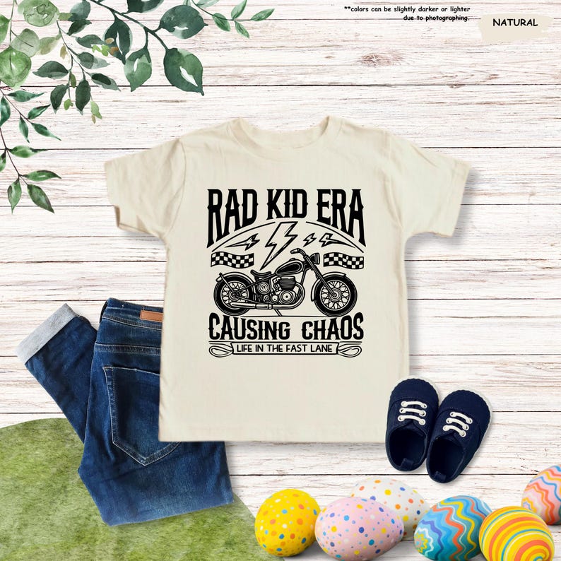 May include: A white t-shirt with a black graphic of a motorcycle and the text "Rad Kid Era", "44", "Causing Chaos", and "Life in the Fast Lane".