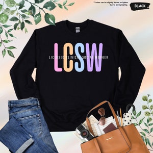 a black sweatshirt with the words lose and a handbag next to it