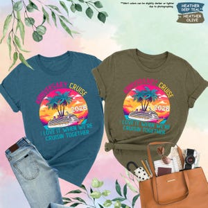 Puede incluir: Dos camisetas, una verde azulado y otra verde oliva, con un dise&ntilde;o de crucero. El dise&ntilde;o incluye una puesta de sol, palmeras y el texto "Anniversary Cruise 2026". La frase "I love it when we're cruisin' together" est&aacute; impresa debajo.