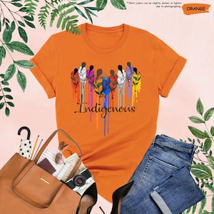 May include: Orange t-shirt with a graphic of colorful feathers and the word "Indigenous" in a dripping paint style.