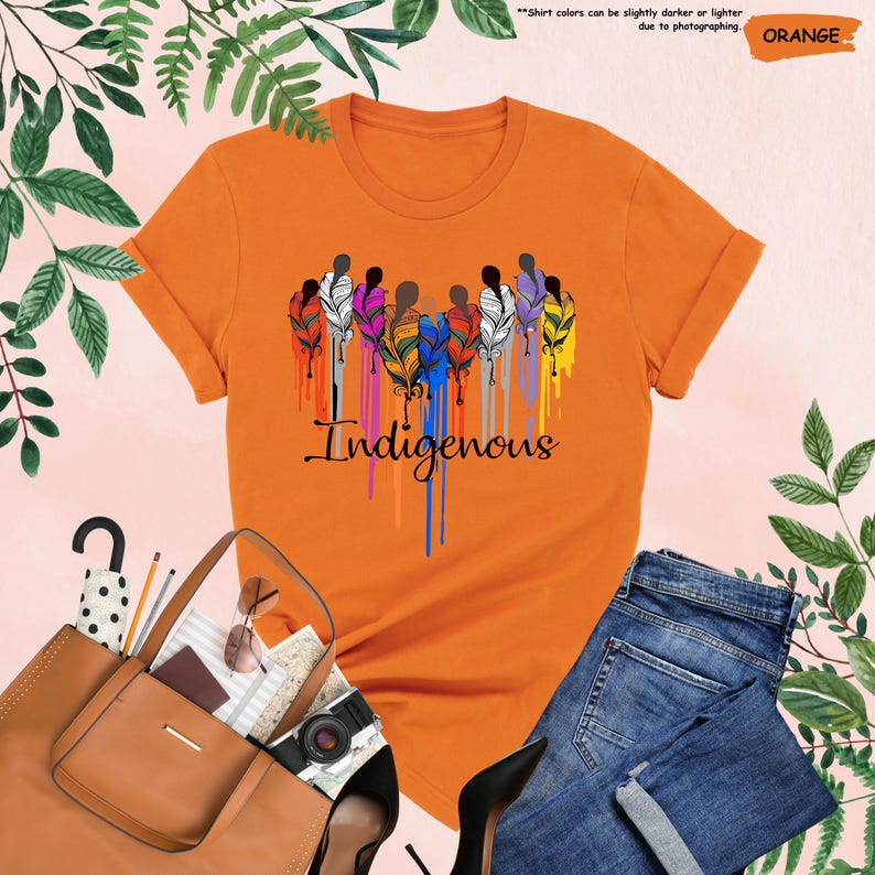 May include: Orange t-shirt with a graphic of colorful feathers and the word "Indigenous" in a dripping paint style.