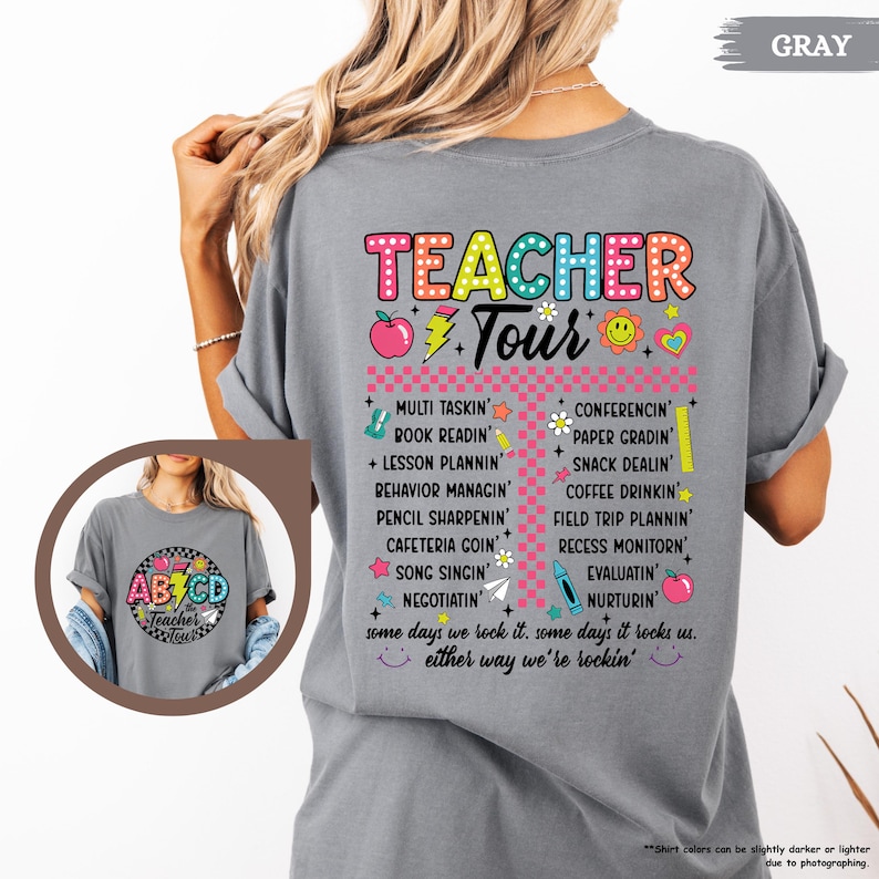 May include: Gray t-shirt with a colorful graphic that says "Teacher Tour" and lists tasks teachers do, such as "Multi Tasking", "Book Readin", "Lesson Plannin", "Behavior Managnin", "Pencil Sharpenin", "Cafeteria Goin", "Song Singin", "Negotiatin", "Conferencing", "Paper Gradin", "Snack Dealn", "Coffee Drinkin", "Field Trip Plannin", "Recess Monitorin", "Evaluatin", and "Nurturin". The graphic also includes a red apple, a yellow sun, and a pink heart.