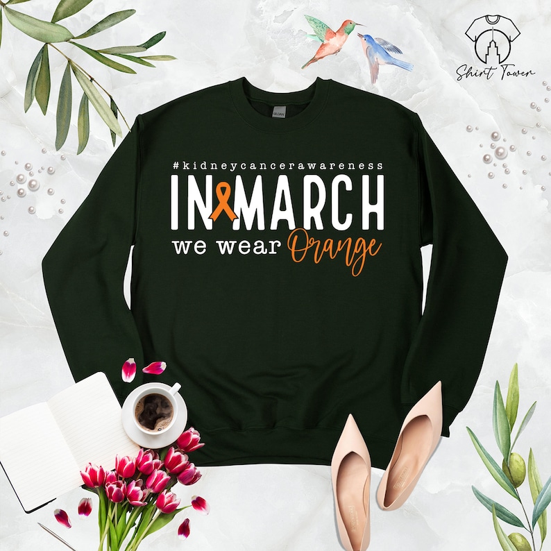 Puede incluir: Sudadera verde con el texto "#kidneycancerawareness IN MARCH we wear Orange" y una cinta naranja.