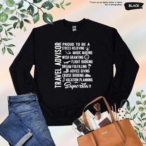 May include: Black long-sleeved sweatshirt with white text that reads "Travel Advisor Proud to be a Stress Relieving Magic Making Wish Granting Flight Booking Dream Fulfilling Advice Giving Cruise Booking Vacation Planning Superstar".