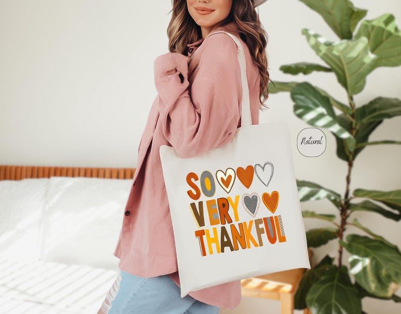 May include: White tote bag with the text "So Very Thankful" in colorful letters and hearts. The bag has a natural fabric label.