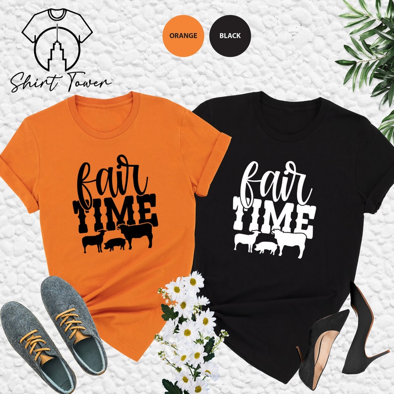 May include: Two t-shirts with the text "fair time" in black and white lettering. The shirts are orange and black and feature a silhouette of farm animals.