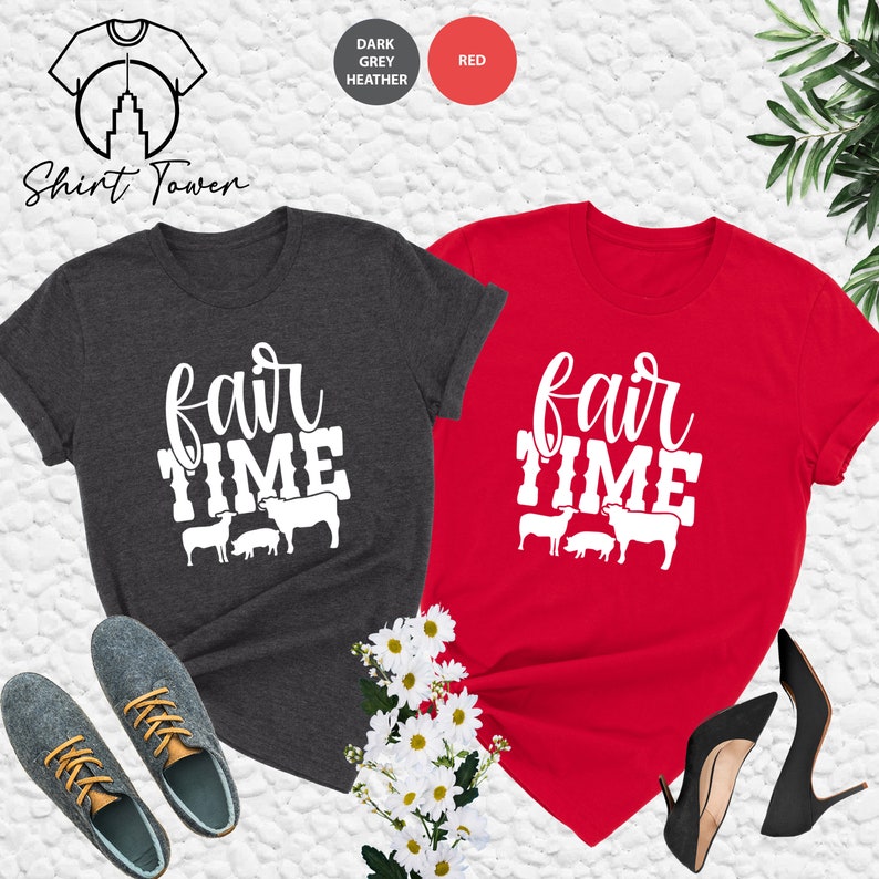 May include: Two t-shirts with the text "fair time" and a graphic of farm animals. The shirts are in dark grey heather and red.