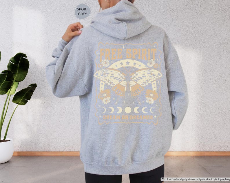 a woman wearing a gray sweatshirt with a graphic on it