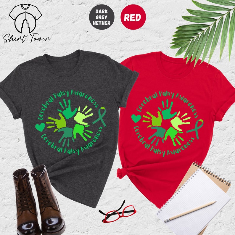 May include: Two t-shirts, one dark heather grey and one red, with a green and yellow handprint design and the text "Cerebral Palsy Awareness".
