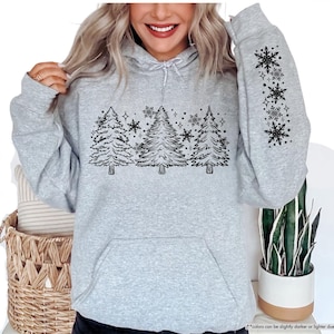 May include: A gray hooded sweatshirt with a black design of stylized pine trees and snowflakes. The design is on the front of the sweatshirt and the sleeve. The text "SPORT GREY" is in a white box on the top left corner of the image.