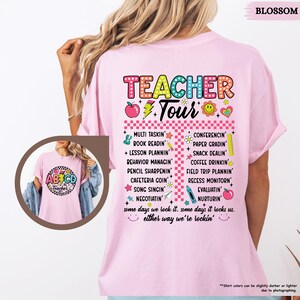 May include: Pink t-shirt with a colorful graphic that says "Teacher Tour" and lists tasks a teacher does, such as "Multi Tasking", "Book Readin", "Lesson Plannin", "Conferencing", "Paper Gradin", "Snack Dealin", and "Coffee Drinkin".