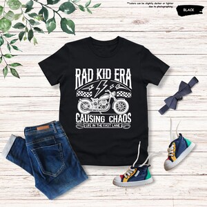May include: Black t-shirt with a white graphic of a motorcycle and the text "Rad Kid Era Causing Chaos Life in the Fast Lane"
