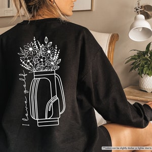 a woman sitting in a chair with a vase of flowers on her back