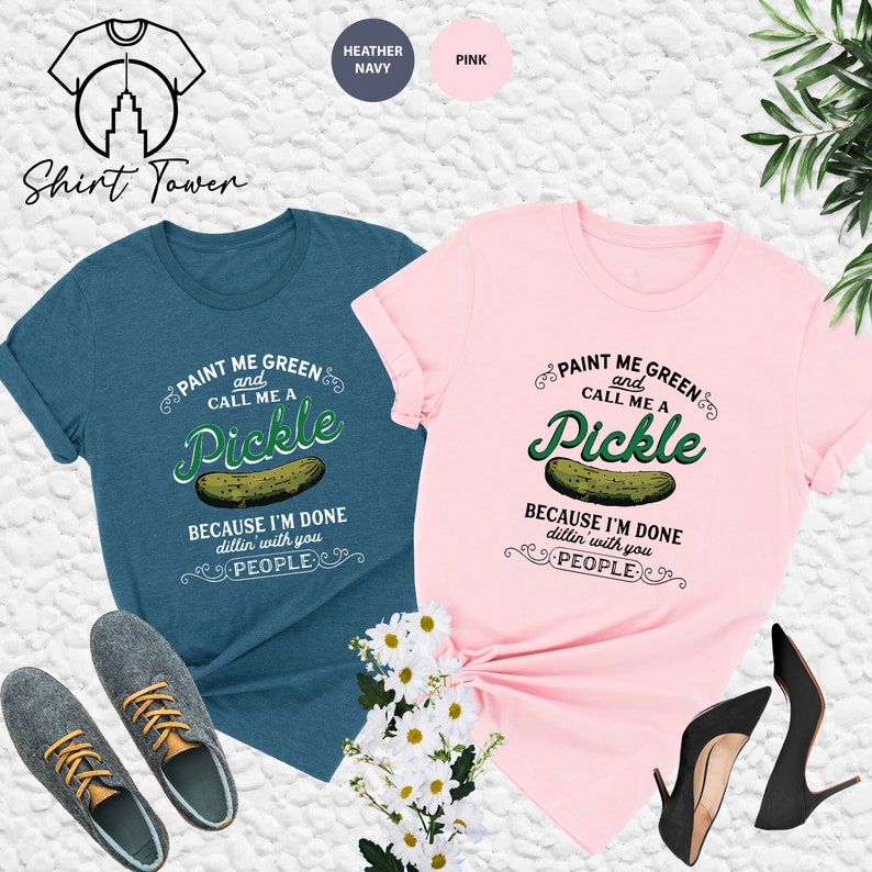 May include: Two t-shirts, one heather navy blue and one pink, with a pickle graphic and the text "Paint me green and call me a pickle because I'm done dillin' with you people".
