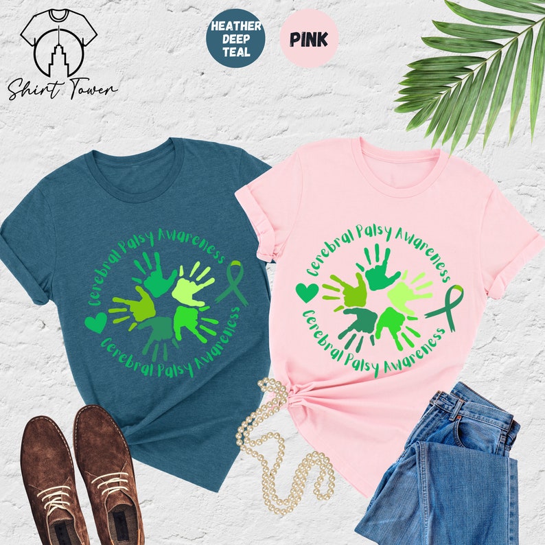 May include: Two t-shirts with a green handprint design and the text "Cerebral Palsy Awareness" in a circle. The t-shirts are in heather deep teal and pink.