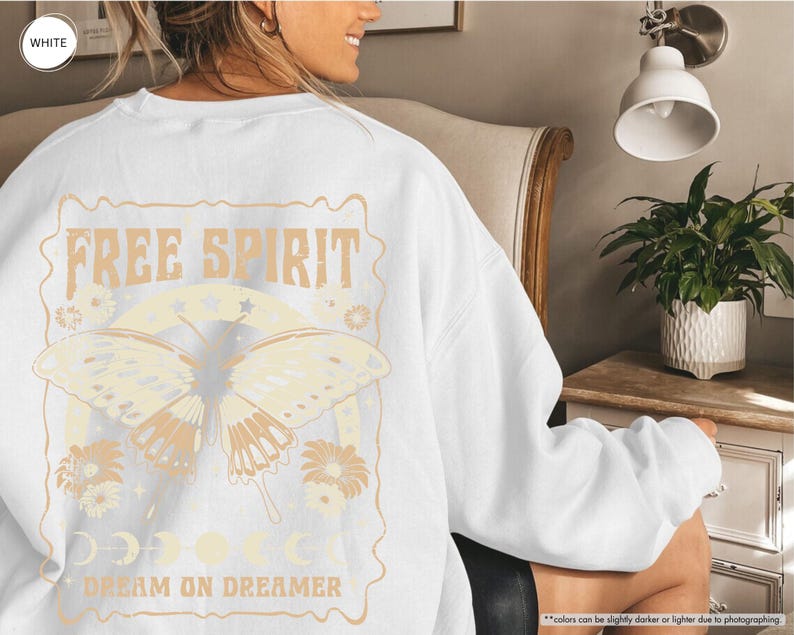 a woman sitting in a chair wearing a white shirt with a butterfly on it