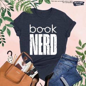 a t - shirt that says book nerd next to a pair of jeans and
