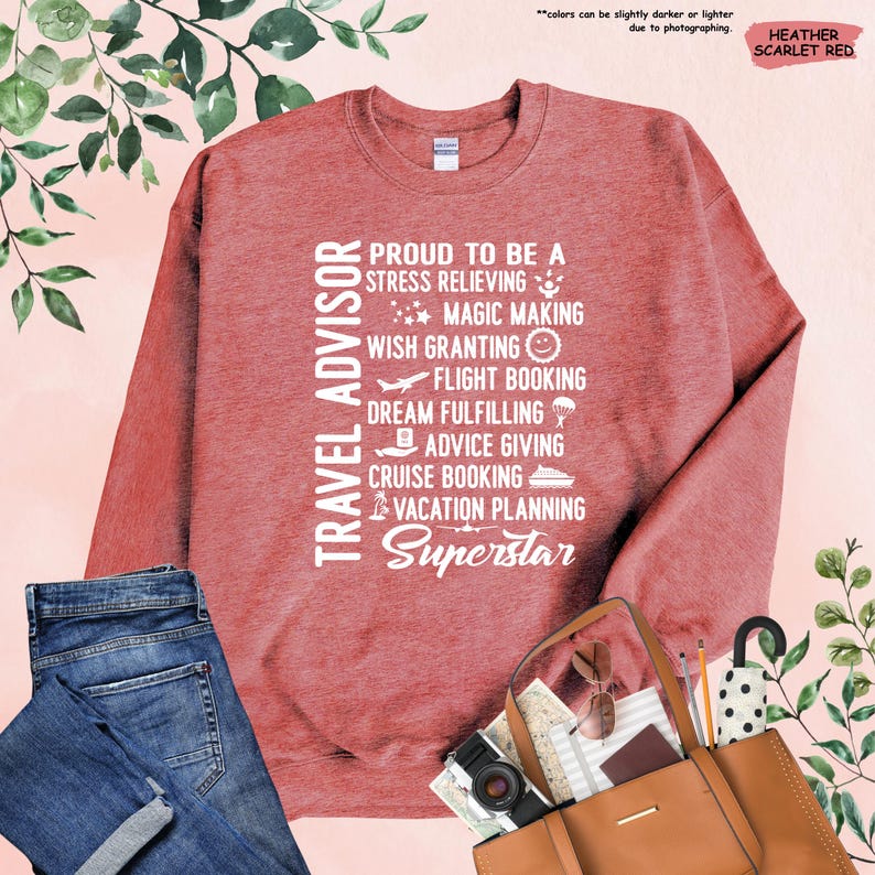 May include: A heather scarlet red sweatshirt with white text that reads "TRAVEL ADVISOR" and "PROUD TO BE A STRESS RELIEVING MAGIC MAKING WISH GRANTING FLIGHT BOOKING DREAM FULFILLING ADVICE GIVING CRUISE BOOKING VACATION PLANNING SUPERSTAR".