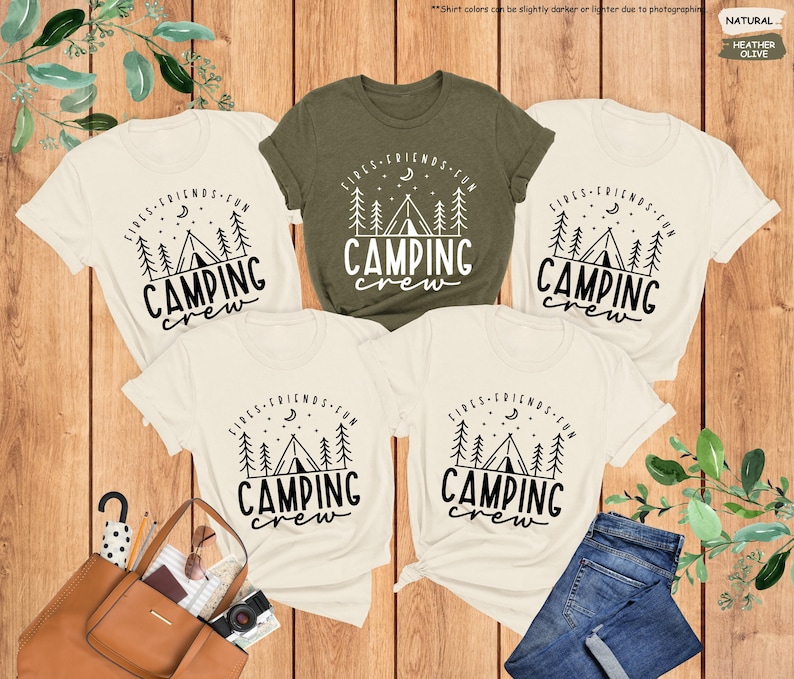 Peut inclure: Quatre t-shirts cr&egrave;me avec du texte noir qui dit "Fires, Friends, Fun, Camping Crew" et un graphique d'un feu de camp et d'une tente. Un t-shirt est de couleur vert fonc&eacute;.