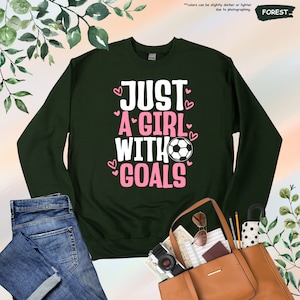 a sweater that says just a girl with goals on it