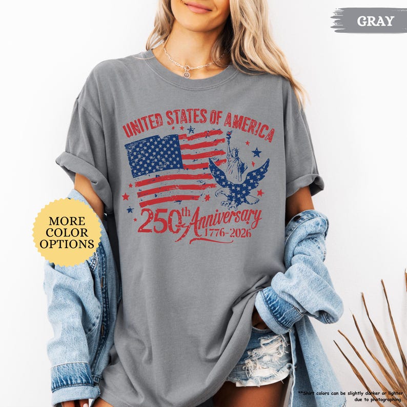 Op de afbeelding: Grijze t-shirt met een distressed afbeelding ter ere van de 250e verjaardag van de Verenigde Staten van Amerika. Het ontwerp toont de Amerikaanse vlag, het Vrijheidsbeeld en de tekst "250th Anniversary 1776-2026".
