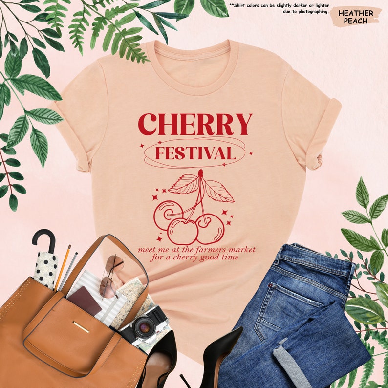 a t - shirt that says cherry festival next to a purse