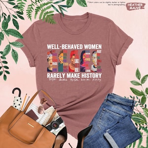 May include: Heather mauve t-shirt with a graphic print of famous women and the text "Well-behaved women rarely make history".