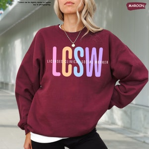 a woman with blonde hair wearing a maroon sweatshirt