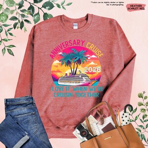 Puede incluir: Sudadera roja escarlata jaspeada con un gr&aacute;fico colorido. El gr&aacute;fico presenta un crucero, palmeras y el texto "ANNIVERSARY CRUISE 2026". Tambi&eacute;n se incluye la frase "I LOVE IT WHEN WE'RE CRUISIN' TOGETHER".