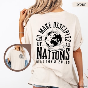 May include: Ivory t-shirt with a black graphic of a hand holding a globe with the text "Go Make Disciples of All Nations Matthew 28:19"