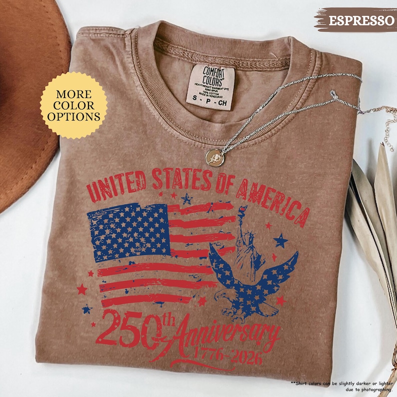 Op de afbeelding: Espresso-kleurig T-shirt met een distressed afbeelding ter herdenking van de 250e verjaardag van de Verenigde Staten van Amerika. Het ontwerp bevat de Amerikaanse vlag, een adelaar en het Vrijheidsbeeld. Het shirt is van het merk Comfort Colors.