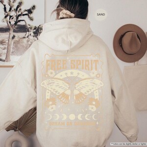a woman wearing a white hoodie with a picture of a butterfly on it