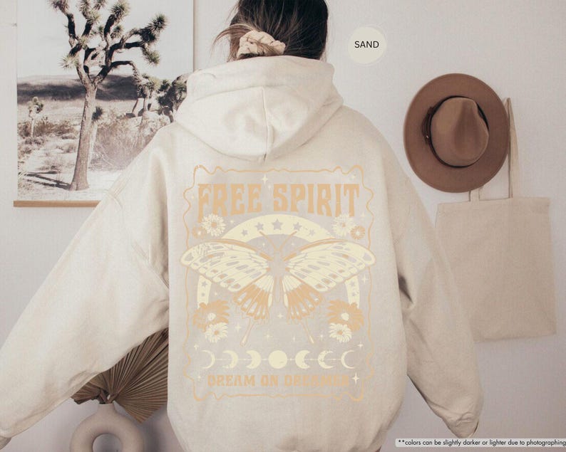 a woman wearing a white hoodie with a picture of a butterfly on it