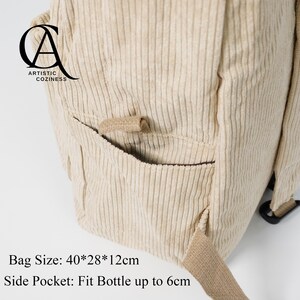 May include: A beige corduroy backpack with a side pocket that can fit a bottle up to 6 inches. The bag has a logo that says "Artistic Coziness" and the text "Bag Size: 40*28*12cm".
