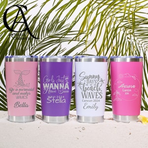 May include: Four stainless steel tumblers with different designs and names. The tumblers are pink, purple, white, and pink. The designs include a mermaid, a girl with a sun, a beach with waves, and a palm tree with a sun. The names on the tumblers are Bella, Stella, Emily, and Aurora.