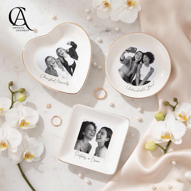 May include: Three white ceramic trinket dishes with gold-toned rims, featuring black and white photographs and text. The heart-shaped dish says Cherished Moments, the round dish says Unbreakable Bond, and the square dish says Partners in Crime.