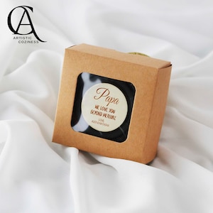 May include: A small brown box with a clear window showing a white round wooden disc with the text "Papa We love you beyond measure Love Alex & Natasha" in brown lettering.