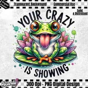 May include: A green frog with a big tongue sticking out sits on a lily pad with pink flowers. The frog has big, round eyes. The text "YOUR CRAZY IS SHOWING" is written in black letters around the frog.