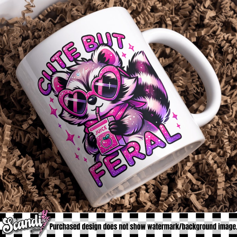 Op de afbeelding: Een witte keramische mok met een roze en paarse illustratie van een wasbeer die een zonnebril draagt en een sappakje vasthoudt. De tekst "CUTE BUT FERAL" staat in roze en paarse letters rond de wasbeer.