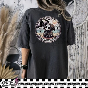 Puede incluir: Camiseta gris oscuro con un gr&aacute;fico circular en la espalda. El gr&aacute;fico muestra una caricatura de la muerte en una playa con el texto "HOT GHOUL SUMMER". La camiseta es de estilo casual.