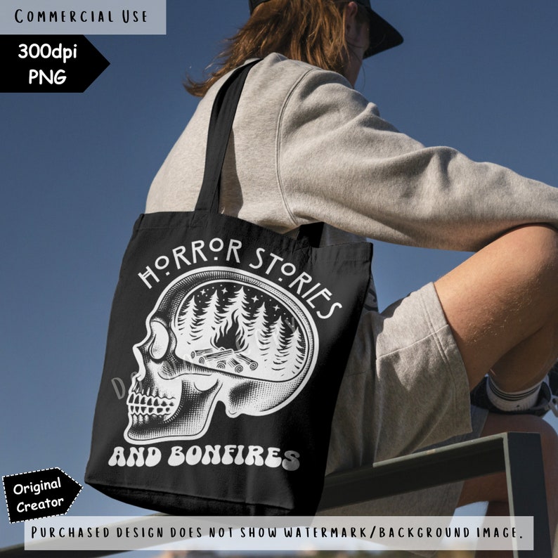 Op de afbeelding: Zwarte tote bag met witte tekst die "Horror Stories and Bonfires" luidt. Het ontwerp bevat een schedel met een bos sc&egrave;ne erin.