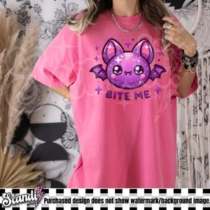May include: Pink t-shirt with a purple cartoon bat with glitter and the text "Bite Me".