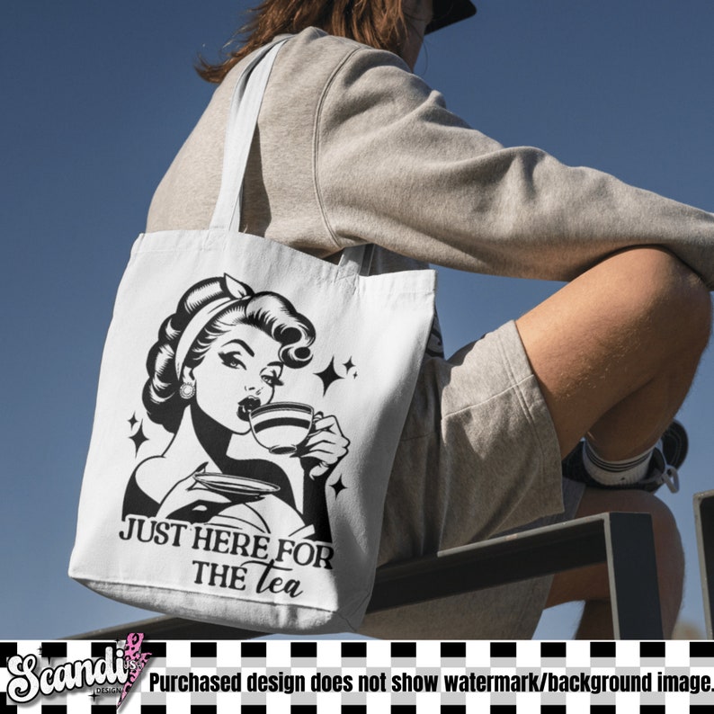 May include: White tote bag featuring a black and white illustration of a woman drinking tea, with the text "JUST HERE FOR THE TEA". The bag has long straps and is made of a sturdy fabric, perfect for carrying items.