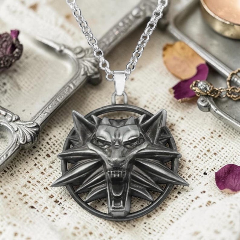 Puede incluir: Collar con colgante plateado con un detallado dise&ntilde;o de cabeza de lobo dentro de un marco circular. El colgante cuelga de una cadena plateada. Este collar es una pieza de joyer&iacute;a llamativa, ideal para los fan&aacute;ticos de los temas de fantas&iacute;a.