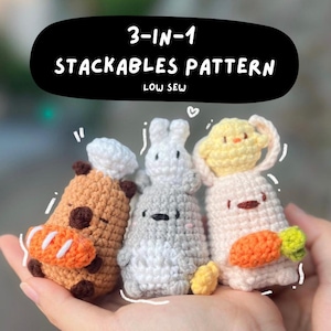 May include: Three crocheted stackable plush toys. The first is a brown bear wearing a chef's hat and holding a carrot. The second is a gray bunny with a white face and holding a yellow flower. The third is a white bunny with a yellow chick on top and holding a carrot.