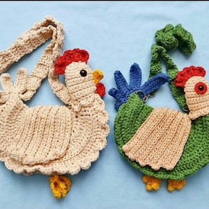 May include: Two crochet chicken-shaped bags. One is beige with a red comb, yellow beak and feet, and a long strap. The other is green with a red comb, blue tail feathers, yellow feet, and a tan patch. Both have black eyes.