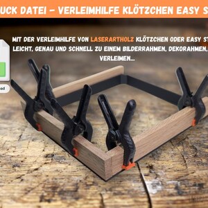 May include: A woodworking project in progress, featuring a wooden frame held together by black clamps with orange tips. The image includes text about 3D printing and the use of the clamps for gluing.
